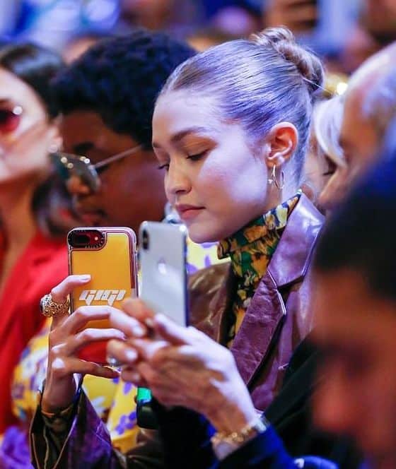 Model Gigi Hadid snaps a photo at a runway show