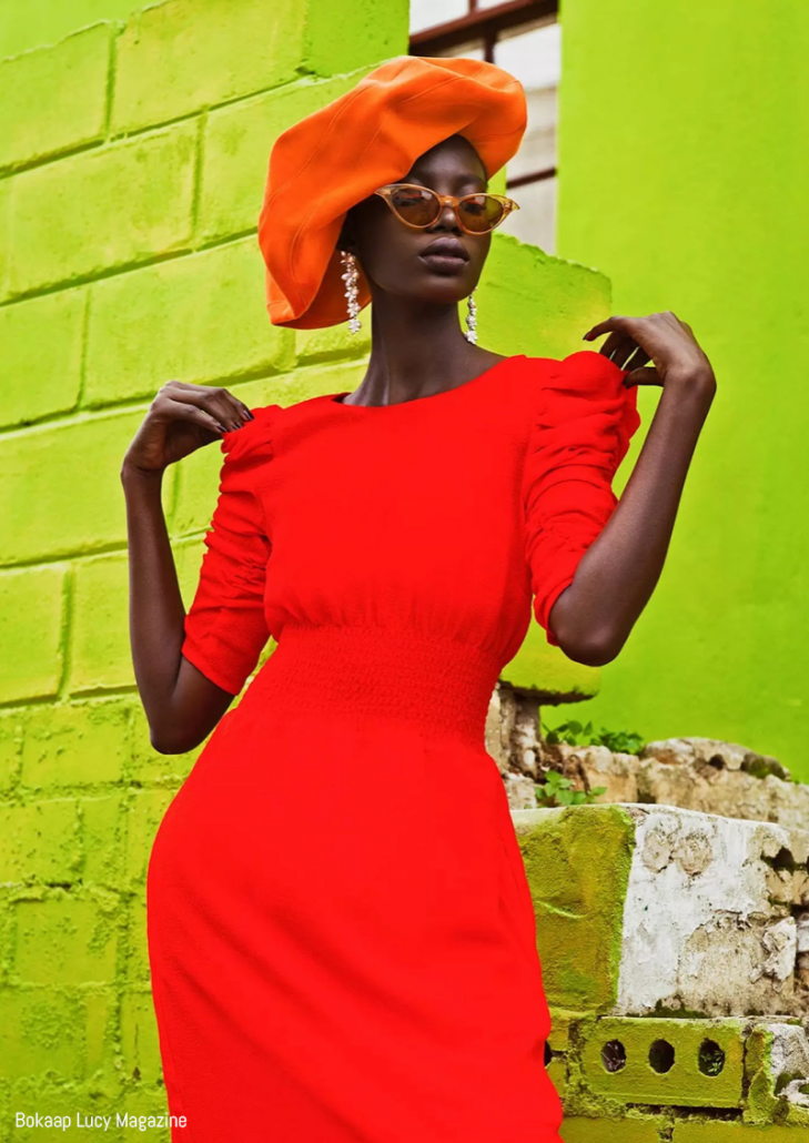 Model poses in orange beret and dress