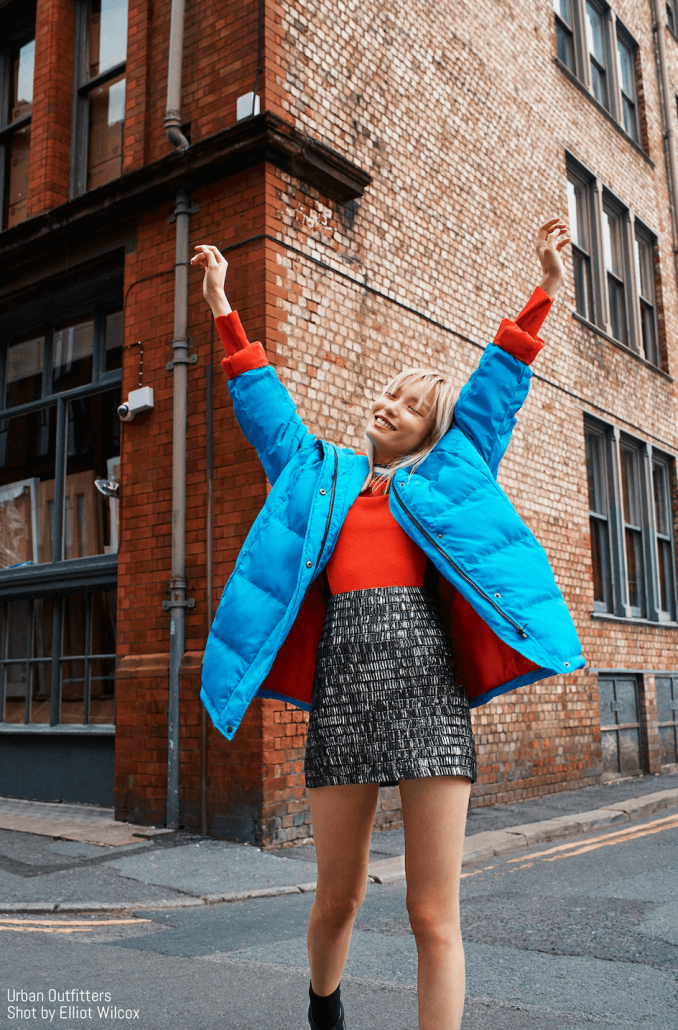 Model poses in puffer jacket and skirt for Urban Outfitters