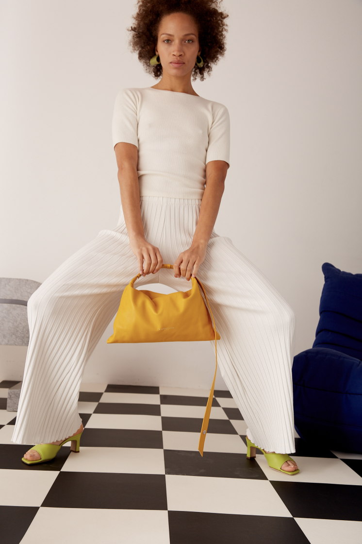 Model poses with yellow bag